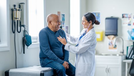 Physician assistant working with a patient who is sitting on a table